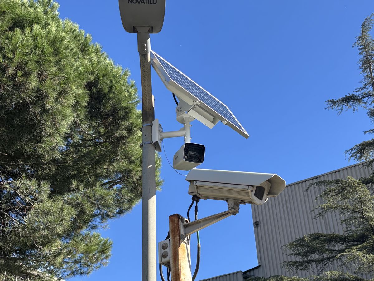 Caméra autonome et panneau solaire sur un mât, chantier en arrière-plan
