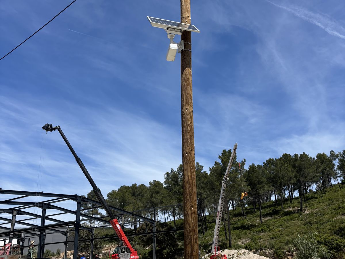 Caméra autonome sur poteau au-dessus d'un chantier avec grue
