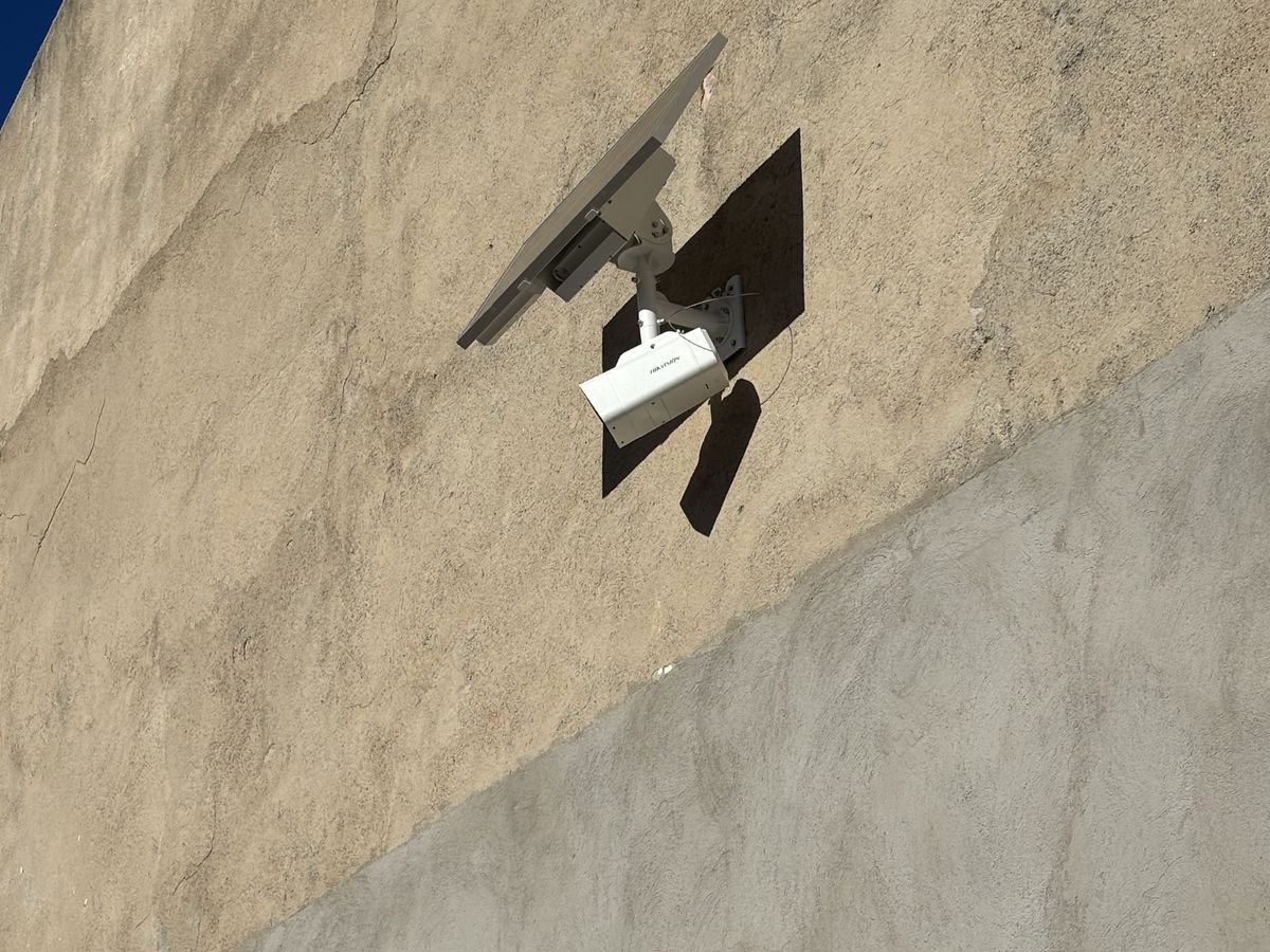Caméra autonome avec panneau solaire fixée sur la façade d'un entrepôt